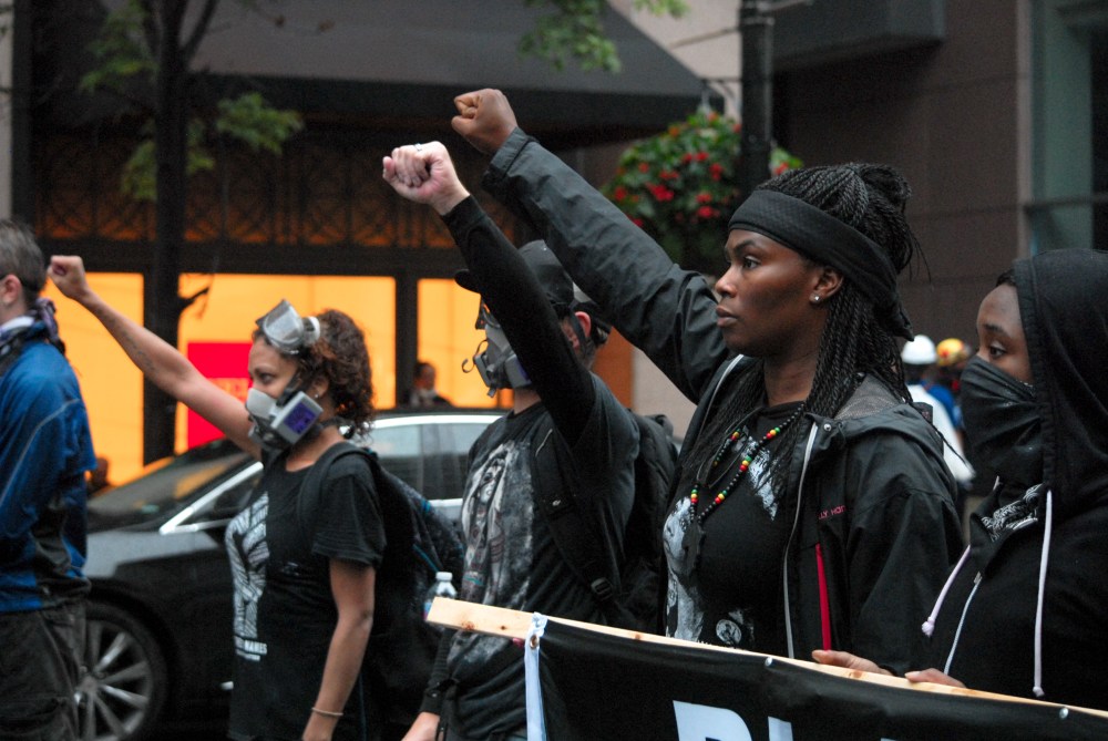 Black Lives Matter activists raise their fists facing police during protest activity in Washington D.C. on Aug. 12, 2018.