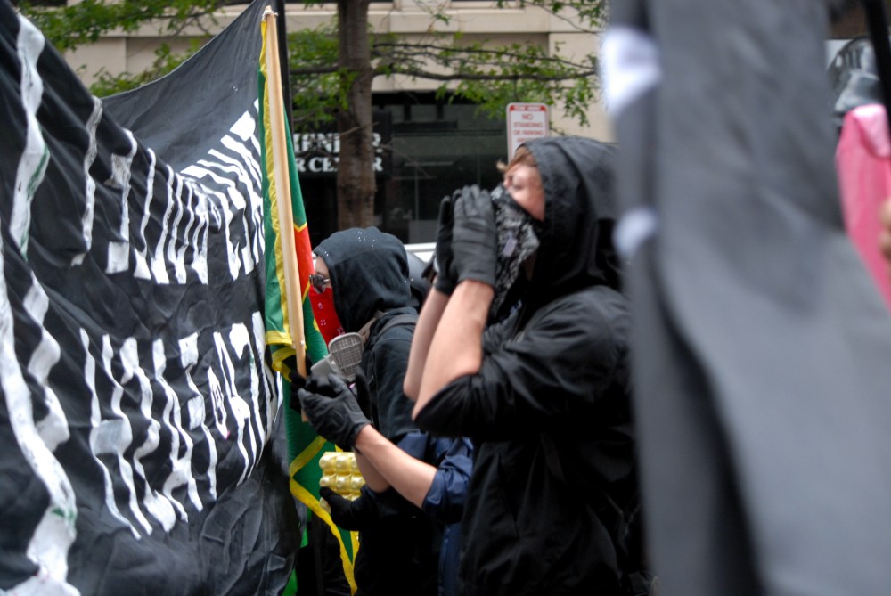 A masked anti-fascist activist yells during protest activity in Washington D.C. on Aug. 12, 2018. 